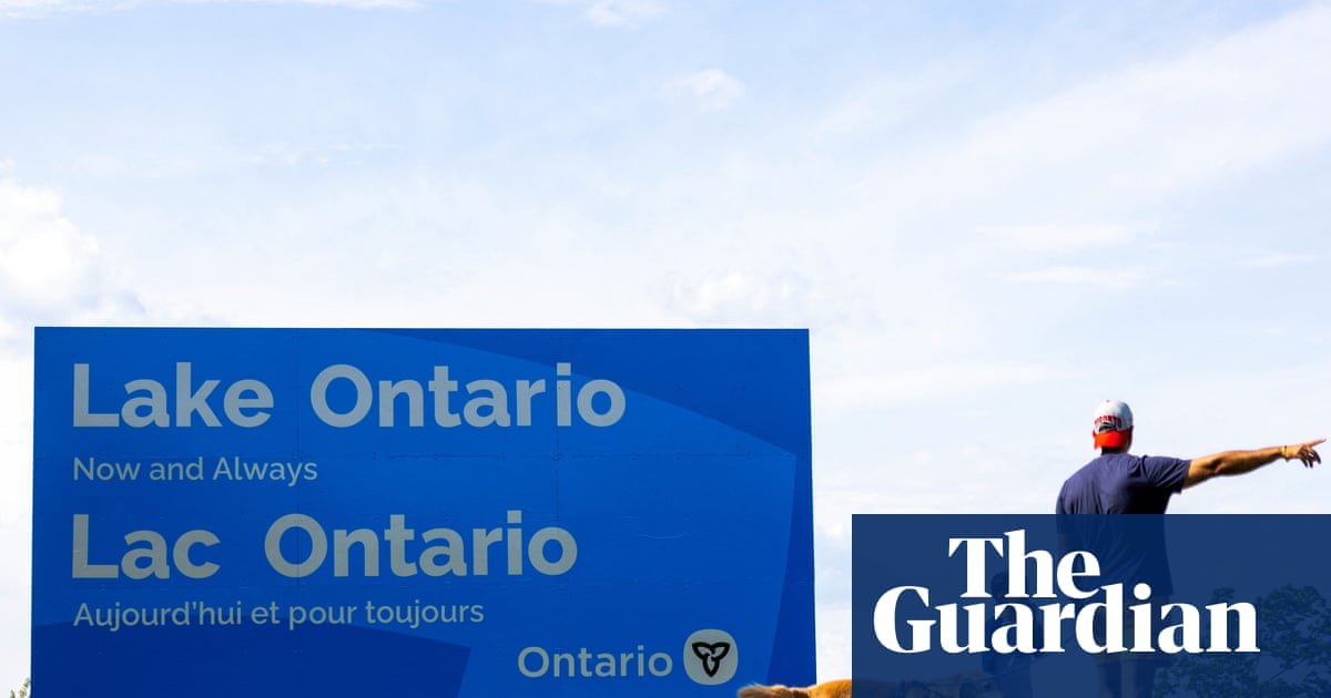 A roadside sign marking a lake boundary beside a highway